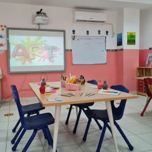"صورة لغرفة الفنية في حي الروابي بمدارس بواكير الأهلية، مليئة بالأعمال الفنية والمواد الإبداعية."