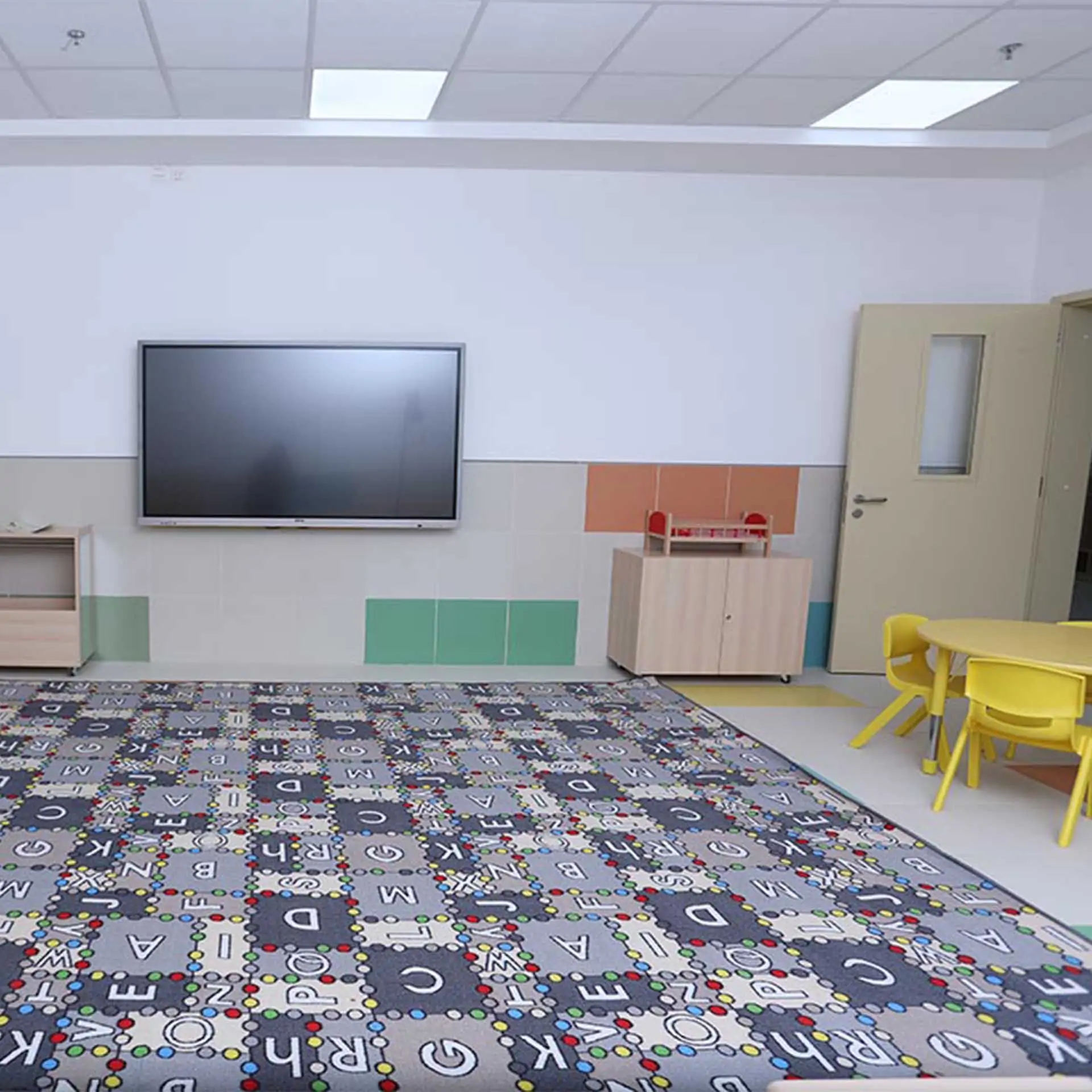 صورة لفصول رياض الأطفال مع شاشة تفاعلية، تعزز التعلم الرقمي.